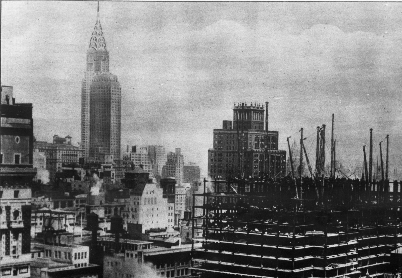 Esqueleto de aço com guindastes no primeiro plano e o Chrysler Building ao fundo