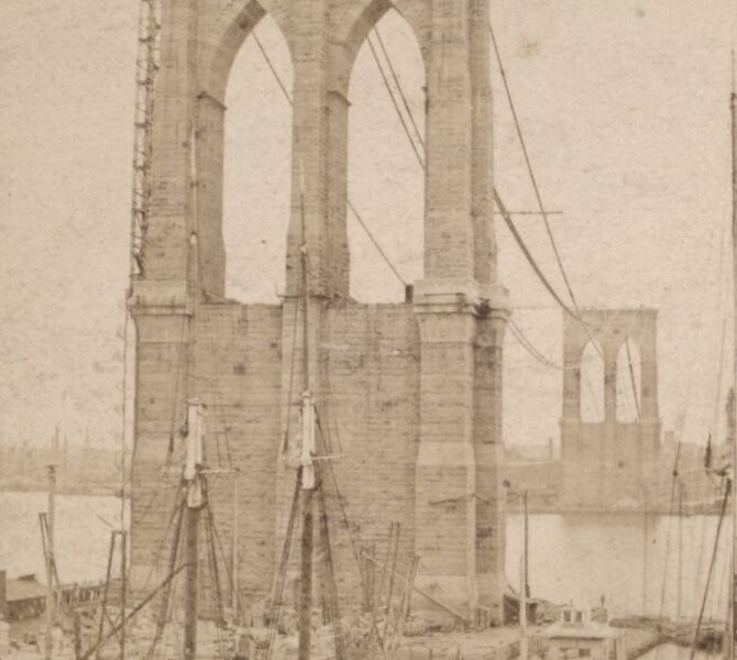 Torre de pedra da ponte em construção, com arcos góticos e andaimes, e a outra torre ao fundo do outro lado do rio