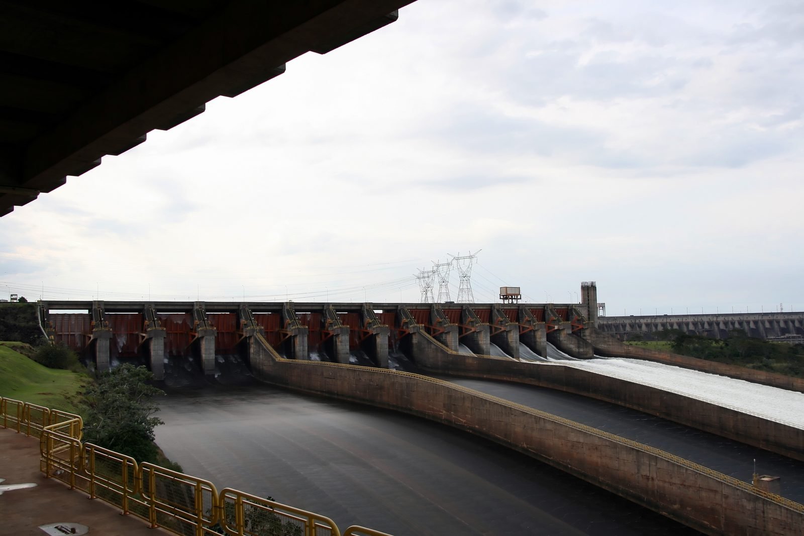 O vertedouro de Itaipu com parte das comportas abertas e a água descendo pelas calhas de concreto